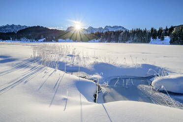 Deutschland, Bayern, Sonnenaufgang über schneebedecktem See in den bayerischen Alpen - ANSF00252