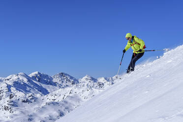 Österreich, Tirol, Skifahrerin rutscht schneebedeckten Hang in den Kitzbüheler Alpen hinunter - ANSF00258