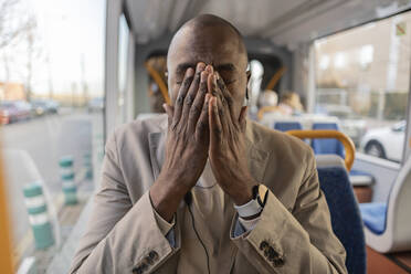 Tired businessman man touching face in cable car - JCCMF09267