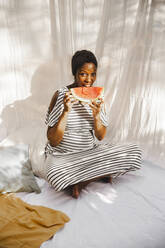 Schwangere Frau isst frische Wassermelone im Hinterhof - PCLF00248