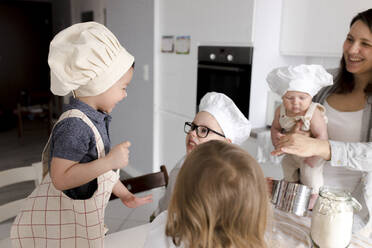 Kinder haben Spaß bei der Zubereitung von Teig in der Küche - VIVF00392