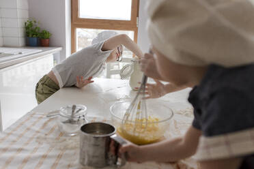 Boy taking flour to prepare dough at home - VIVF00400