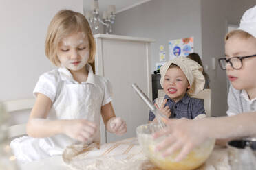 Children preparing dough with flour in kitchen - VIVF00405