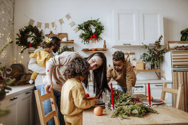 Glückliche Familie, die zur Weihnachtszeit Zeit in der Küche verbringt - MDOF00580