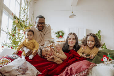 Glückliche Eltern mit Töchtern und Sohn genießen Weihnachten - MDOF00592