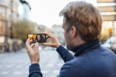 Mann spricht mit Frau per Videoanruf über Smartphone - JOSEF16558