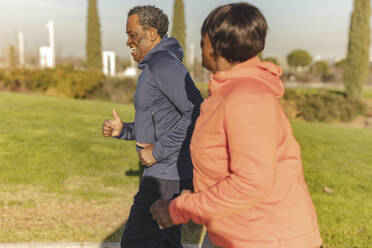 Älterer Mann mit Frau beim Joggen im Park - JCCMF09315