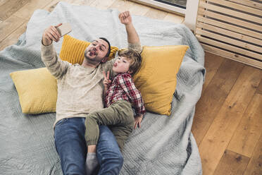 Sohn mit Vater nimmt Selfie durch Smartphone zu Hause - UUF28113