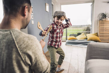 Vater und Sohn spielen zu Hause mit Spachteln - UUF28119