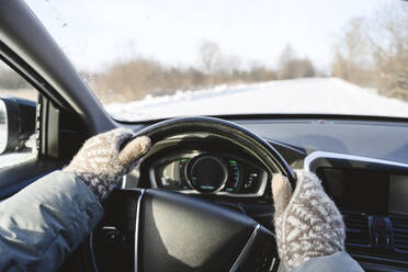 Mann mit Fäustlingen beim Autofahren im Winter - EYAF02562