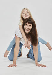 Verspielte Mutter und Tochter haben Spaß vor weißem Hintergrund - DHEF00679