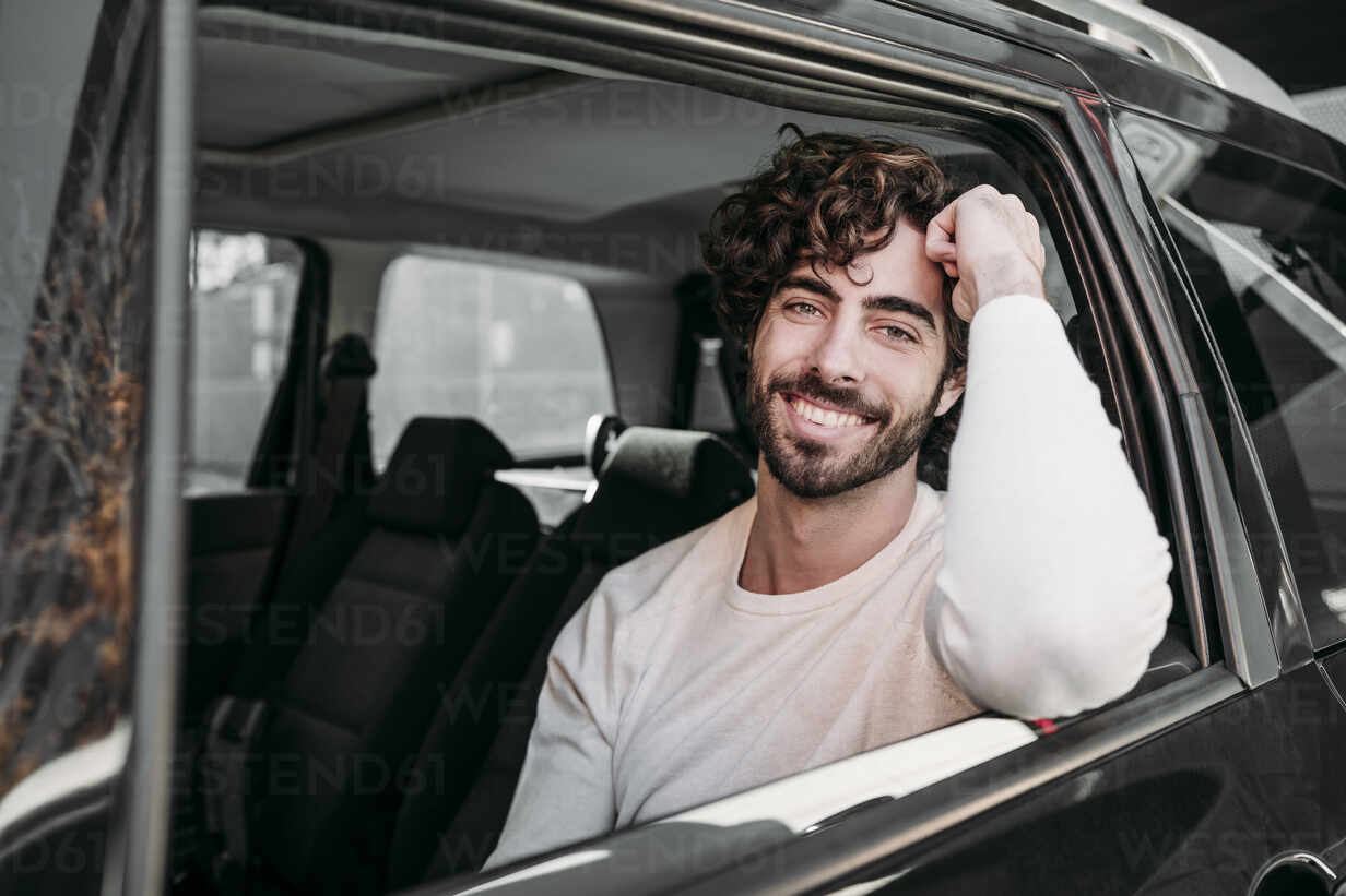Junger Mann beim Anschnallen im Auto sitzend, lizenzfreies Stockfoto
