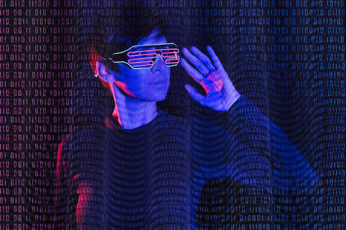 Mature woman wearing futuristic glasses with binary code - JSMF02653