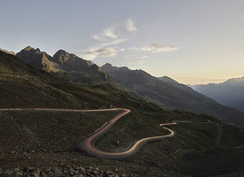 Austria, Vehicle light trails stretching along winding mountain pass in Alps - CVF02290