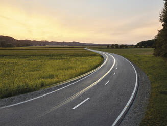 Austria, Vehicle light trails stretching along country road at dusk - CVF02296