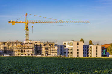 Deutschland, Baden-Württemberg, Fellbach, Wiese vor im Bau befindlichen Wohnhäusern - WDF07234