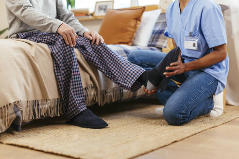 Physical therapist examining man's ankle during physical therapy session - EBSF02679