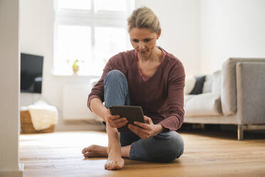 Reife Frau vor Tablet-PC sitzend zu Hause - JOSEF16692