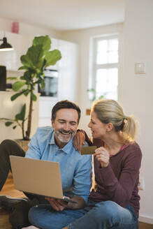 Ein glückliches Paar genießt das Online-Shopping zu Hause - JOSEF16716