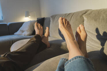Beine eines Paares auf dem Sofa im Wohnzimmer - JOSEF16784
