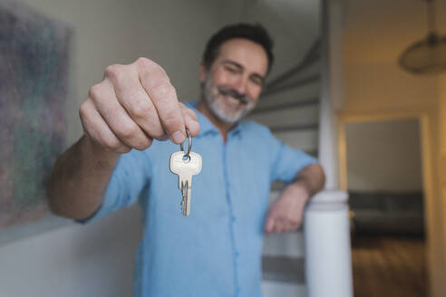 Lächelnder reifer Mann zeigt Hausschlüssel - JOSEF16812