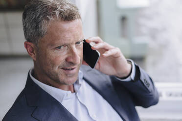 Mature businessman talking on mobile phone - KNSF09649