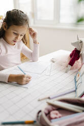 Girl writing in book doing homework at home - SSYF00089