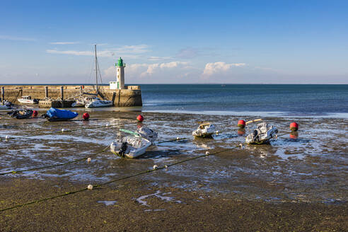 Frankreich, Nouvelle-Aquitaine, La Flotte, Boote links am Strand mit Leuchtturm im Hintergrund - WDF07240