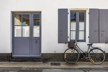 France, Nouvelle-Aquitaine, Ars-en-Re, Bicycle left in front of house - WDF07246