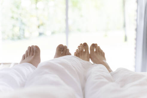 Feet of man and woman under blanket - CHPF00865