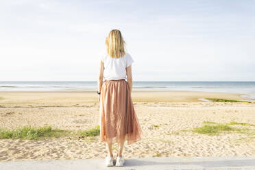 Frau am Strand stehend an einem sonnigen Tag - CHPF00867