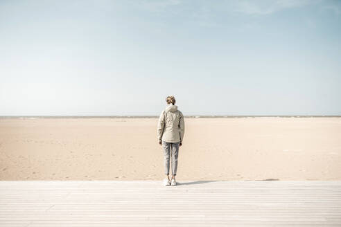 Frau steht auf der Strandpromenade am Strand - CHPF00872