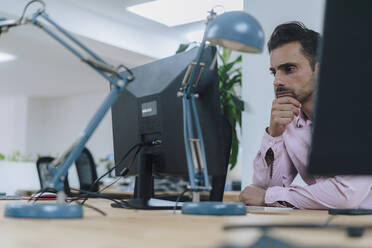 Älterer Geschäftsmann sitzt vor einem Desktop-PC im Büro - JOSEF16956