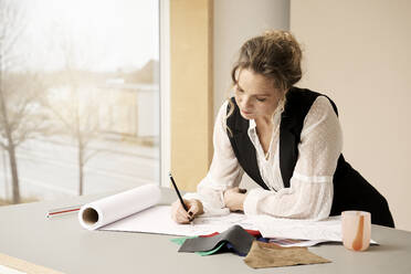 Kreative professionelle Skizze auf Papier mit Bleistift am Tisch - RSKF00016