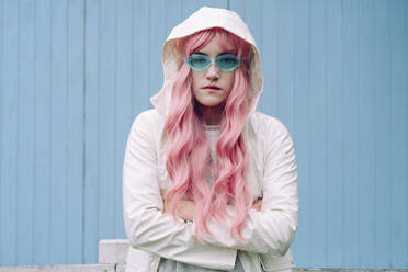 Woman with pink hair standing in front of wall - YTF00508