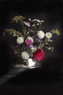 Arrangement aus Kräutern und blühenden Herbstblumen auf dem Klavier - EVGF04267