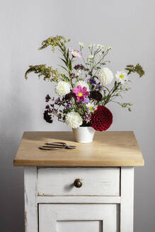 Arrangement aus Kräutern und blühenden Herbstblumen auf dem Nachttisch - EVGF04268