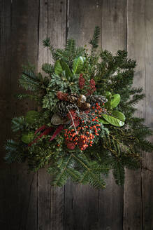 Autumnal arrangement of twigs, laurel, amaranthus, skimmia, rose hips and pine cones - EVGF04290