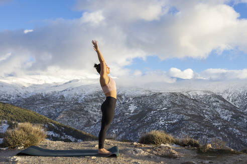Woman doing stretching exercise on mountain - LJF02474