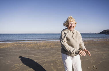 Sorglose ältere Frau tanzt und hat Spaß am Strand - UUF28167