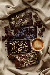 Von oben Komposition von verschiedenen hausgemachten Schokoladentafeln mit heißem Kaffeebecher - ADSF43133