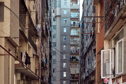 Exterior of high rise building with electric wires and linen drying on ropes on sunny day in ghetto in Batumi, Georgia - ADSF43161