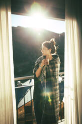 Brunette girl having a coffee for breakfast next to the terrace - CAVF96579