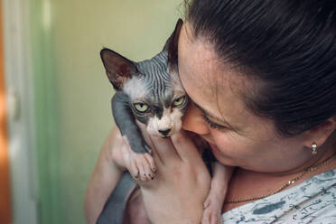 Frau mit Sphynx-Katze und Küssen - CAVF96585