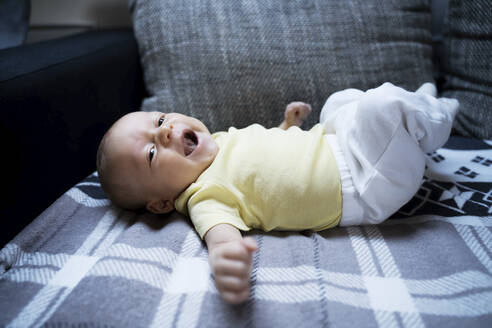 Kleiner Junge gähnt auf dem Sofa zu Hause - NJAF00222