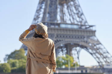 Frau mit Baskenmütze mit Blick auf den Eiffelturm, Paris, Frankreich - KIJF04536