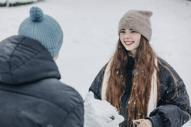 Glückliche Frau sieht ihren Freund im verschneiten Park an - VSNF00413
