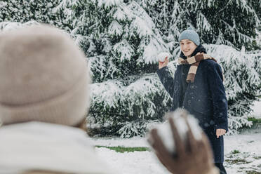 Freund und Freundin spielen mit Schneebällen im Park - VSNF00418