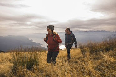 Mann und Frau wandern auf einem Berg bei Sonnenuntergang - UUF28228