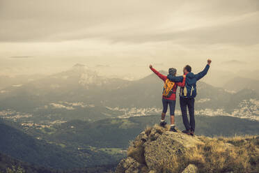 Carefree couple standing on rock under sky - UUF28247